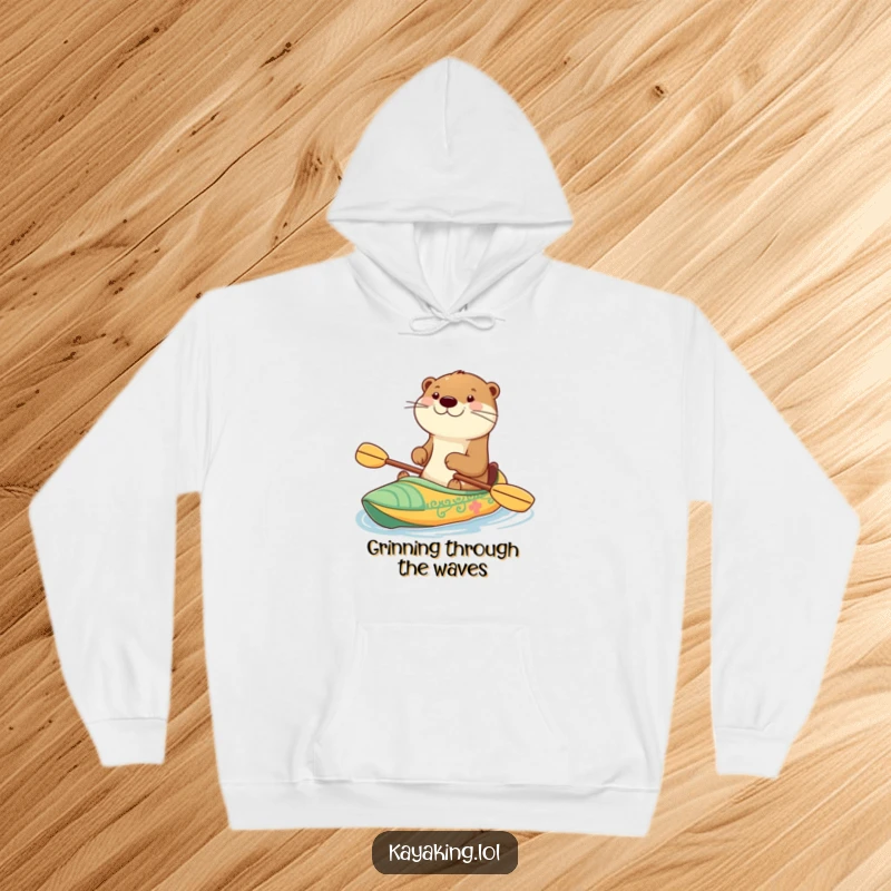 Funny hoodie showing a happy otter with a wide grin paddling a decorated kayak, designed for comfort and a cheerful vibe.