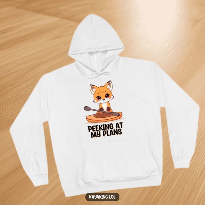 Funny hoodie with a curious fox peeking over the edge of a small kayak, offering comfort and a sense of playful adventure.